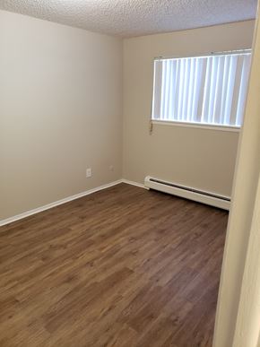 Colorado Springs apartment for rent - an empty room with wooden floors and a window