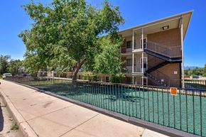 Colorado Springs apartment for rent - A tree is in front of a two-story apartment building.