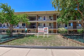 Colorado Springs apartment for rent - Apartment complex with a pool and a sign that says 1010 Delaware.