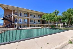 Colorado Springs apartment for rent - A multi-story apartment building with a pool in front.