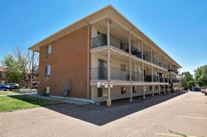 Colorado Springs apartment for rent - A multi-story apartment building with a parking lot in front.