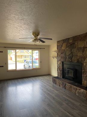 Sandpoint house for rent - a living room with a fireplace and a ceiling fan