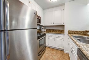 Woodland Hills apartment for rent - a kitchen with stainless steel appliances and white cabinets