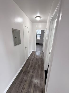 Brooklyn apartment for rent - A long hallway with white walls and wood flooring.