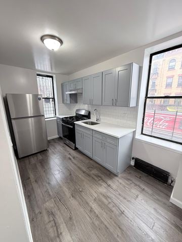 Brooklyn apartment for rent - A kitchen with a stainless steel refrigerator and a white countertop.