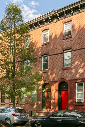Philadelphia apartment for rent - a red brick building with cars parked in front of it