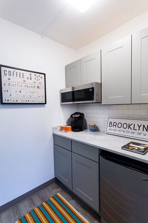 Brooklyn apartment for rent - a small kitchen with white cabinets and a counter top and a microwave