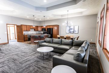 Sioux Falls townhouse for rent - a living room with couches and a kitchen with a table and chairs