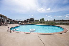 Sioux Falls townhouse for rent - a resort style pool with lounge chairs around it and a building in the background