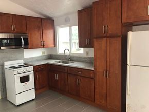 Honolulu apartment for rent - an empty kitchen with wooden cabinets and white appliances