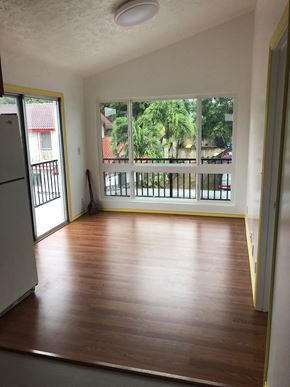 Honolulu apartment for rent - an empty living room with wooden floors and a large window
