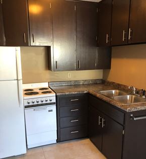 Alexandria apartment for rent - an empty kitchen with white appliances and brown cabinets