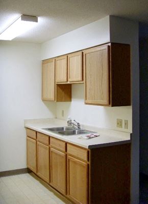 St Peter apartment for rent - A kitchen with wooden cabinets and a white counter.