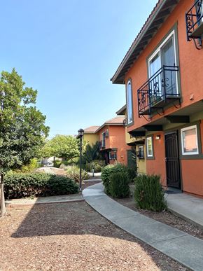 Newark apartment for rent - a sidewalk in front of a building with trees and bushes