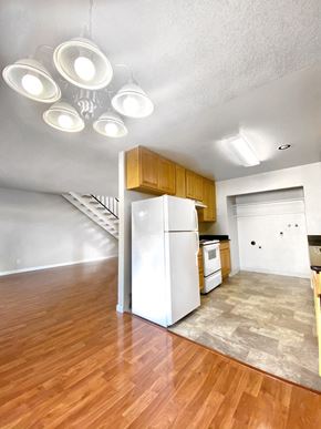 Newark apartment for rent - an empty living room with a kitchen and a refrigerator