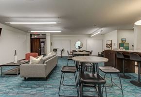 Grand Forks apartment for rent - a lounge area with tables and chairs in a lobby