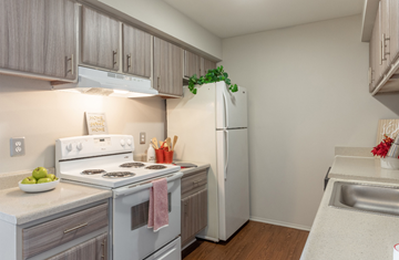 Farmington Hills apartment for rent - a kitchen with white appliances and wooden flooring and a white refrigerator