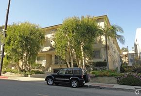 Los Angeles apartment for rent - A black car is parked in front of a two-story building.