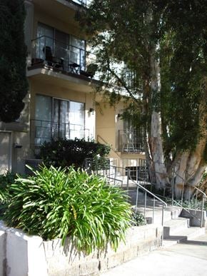 Los Angeles apartment for rent - A building with a balcony and a tree in front.
