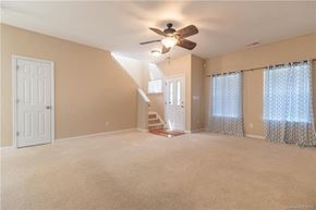 Cornelius house for rent - A spacious room with a staircase and a ceiling fan.
