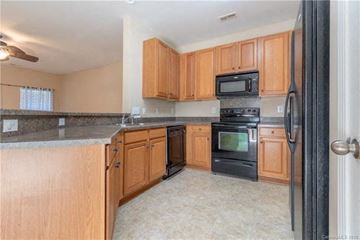 Cornelius house for rent - A kitchen with wooden cabinets and black appliances.