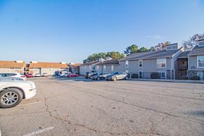 Maumelle apartment for rent - a parking lot with cars parked in front of apartment buildings