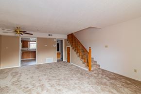 Little Rock townhouse for rent - an empty living room with a staircase and a ceiling fan