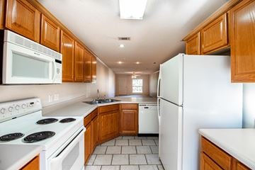 Maumelle apartment for rent - a kitchen with white appliances and wooden cabinets