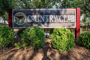 North Little Rock apartment for rent - a sign for the country club in front of trees and bushes