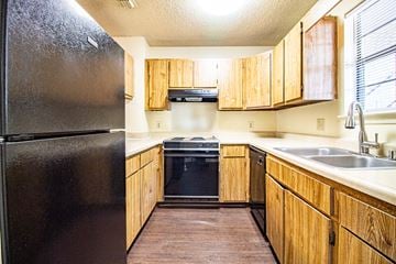 North Little Rock apartment for rent - a kitchen with wooden cabinets and a black refrigerator