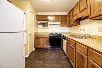 Sherwood condo for rent - a kitchen with wooden cabinets and a refrigerator and a sink