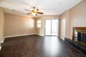 Sherwood condo for rent - an empty living room with a fireplace and a ceiling fan