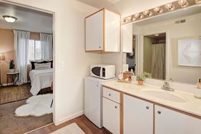 Davis apartment for rent - a kitchen with white cabinets and a sink and a microwave