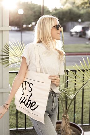 Davis apartment for rent - Young woman holding a bag that says Its a vibe