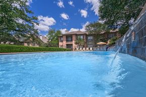 Baton Rouge apartment for rent - a large swimming pool with a fountain in front of a house