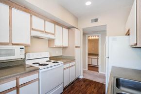 Baton Rouge apartment for rent - a kitchen with white appliances and white cabinets