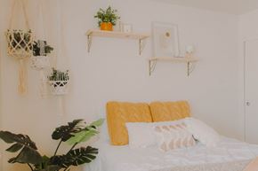 Davis apartment for rent - a white bedroom with a bed with white and yellow pillows and plants