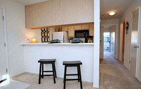 Woodland apartment for rent - a kitchen with two stools in front of a bar
