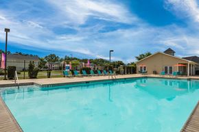 Gulfport apartment for rent - A large swimming pool with a wooden deck and lounge chairs.