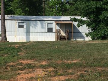 Laurens house for rent - a house with a porch and a fence in a field