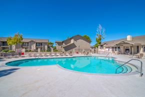 Lancaster apartment for rent - A large outdoor swimming pool surrounded by a concrete patio and residential buildings.