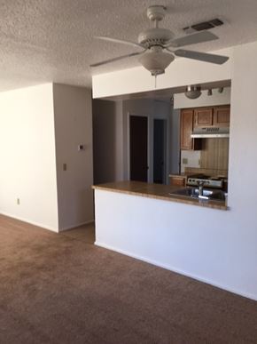 Snyder house for rent - an empty living room with a kitchen and a ceiling fan