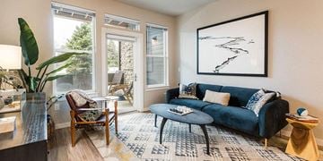 Westminster apartment for rent - A living room with a blue couch and a large painting on the wall.