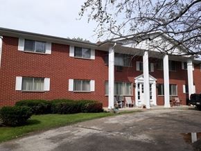 Hartland apartment for rent - A red brick building with white columns and a white door.