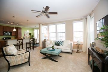 Frederick apartment for rent - living room at VistaView apartments in Frederick, MD with couch, chairs, coffee table, console table and wall mounted TV, and view of counter seating