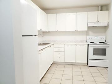 Oshawa apartment for rent - a white kitchen with white appliances and white cabinets