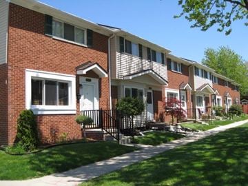 Roseville apartment for rent - A row of houses with a sidewalk in front.
