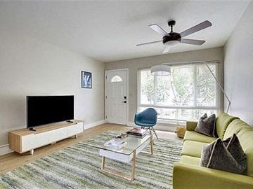 San Jose apartment for rent - a living room with a yellow couch and a ceiling fan
