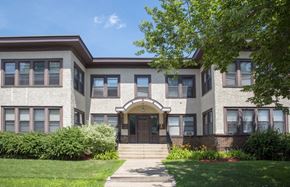 Minneapolis apartment for rent - the front of a brick building with steps and a lawn