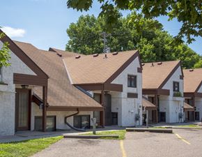 Minneapolis apartment for rent - a group of houses with brown roofs and a parking lot